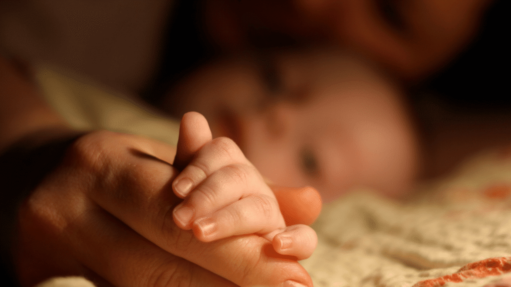 a new born holding his mother's finger